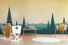 a living room with a wall mural that has trees on it and a chair in the foreground