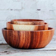 three wooden bowls are stacked on top of each other