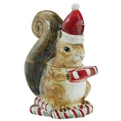 a ceramic figurine of a squirrel holding a candy cane and wearing a santa hat