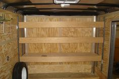 the inside of a trailer with shelves and wheels