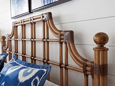 a wooden headboard with blue pillows and pictures on the wall above it, along with other decorative items