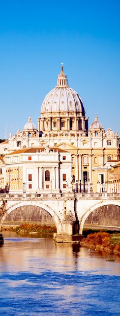 a large building sitting on top of a river next to a bridge