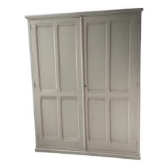 a white armoire with four doors on the front and two drawers on the back