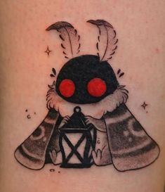 a tattoo with a cartoon character holding a lantern on it's thigh that has red eyes