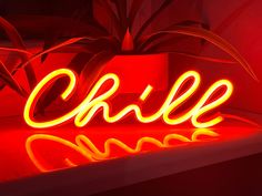 a neon sign that says chille on it's side in front of a plant