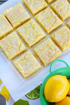 lemon bars are cut into squares and placed next to some lemons on a table