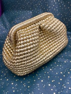 a gold purse sitting on top of a blue tablecloth with white stars around it