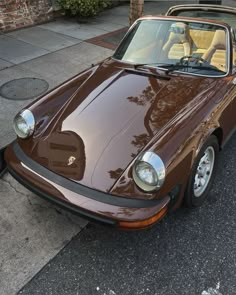 a brown sports car parked on the side of the road