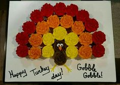 there is a turkey made out of cupcakes on a plate with flowers in the middle