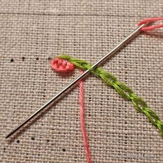 the needle is hooked up to thread on the table cloth with red and green yarn