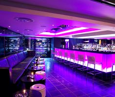 the bar is lit up with purple lights