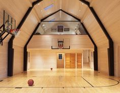 an indoor basketball court with hardwood floors and walls, is shown in this image from the inside