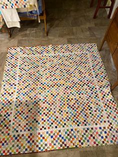 a multicolored patchwork quilt on the floor