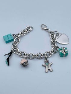 For Sale on 1stDibs - Charming charm bracelet. Made and signed by TIFFANY & CO. Sterling silver bracelet, with a sterling heart charm and five enamel figural charms: a Tiffany Tiffany And Co Charm Bracelet, Luxury Hallmarked Charm Bracelet Gift, Luxury Removable Charms For Gifts, Designer Enamel Jewelry For Gift, Designer Enamel Jewelry As A Gift, Luxury Logo Charm Bracelet As Gift, Luxury Charm Bracelet With Logo Charm As Gift, Elegant Charm Bracelet With Logo Charm As Gift, Silver Bracelets With Logo Charm As Gift