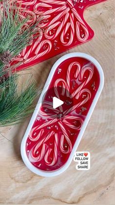 two red trays sitting on top of a wooden table next to a pine tree