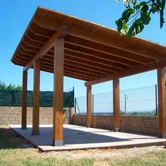 an outdoor covered patio area with benches and table in the foreground on a sunny day