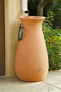 a large brown vase sitting on top of a cement floor next to a planter