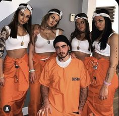 a group of women in orange prison uniforms posing for a photo with one man wearing an orange prison uniform