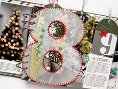 an open christmas scrapbook with ornaments and decorations on the pages, including a tree