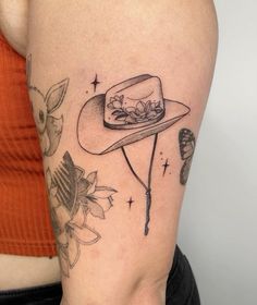 a woman's arm with a hat and scissors on it