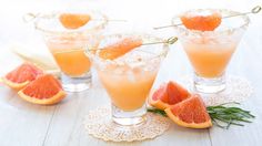 grapefruit cocktails with rosemary garnish and orange slices on the side