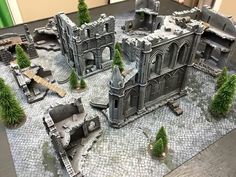 an image of a model castle set up on the table with trees in front of it