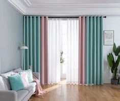 a living room filled with furniture and a large window covered in blue and pink curtains