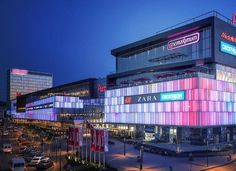 a large building with many windows and lights on it's sides at night time