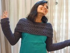 a woman standing in front of a window with her hand up to the ceiling and smiling