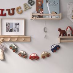 there is a wall with some toys on the shelves and pictures hanging from it's sides