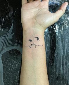 a person's hand with a small tattoo on the wrist that says love birds