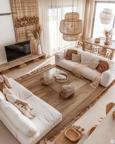 a living room filled with white furniture and lots of natural decor on top of it