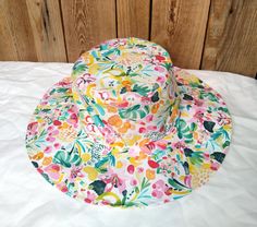 Cotton sun hat made of soft organic cotton. Decorated with a multi-colored floral print, it will fit almost any spring-summer stylization.  Summer hats should be useful, stylish, lightweight and breathable. The hat available in our offer fits perfectly into these aspects, it is an element of clothing that protects the head from the hot rays of the sun. Hat made of airy, certified cotton poplin. The brim of the hat is slightly stiffened, which facilitates modeling. However, this does not prevent Cotton Bucket Hat For The Beach, Spring Multicolor Bucket Hat With Uv Protection, Multicolor Uv Protection Bucket Hat For Spring, Cotton Sun Hat With Uv Protection, Pink Cotton Sun Hat With Uv Protection, Playful Multicolor Sun Hat For Spring, Playful Cotton Sun Hat For Vacation, Fun Cotton Sun Hat For Vacation, Playful Cotton Sun Hat Cap