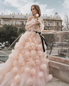 a woman in a pink dress standing on steps