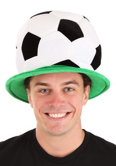 a man wearing a green hat with a soccer ball on it's top,