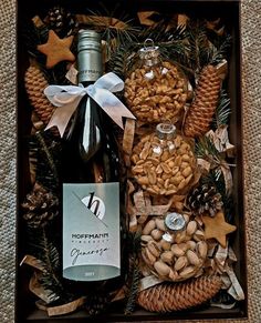 a bottle of wine and nuts in a gift box with pine cones, star decorations