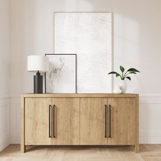 a wooden sideboard with two vases and a plant on it in front of a white wall