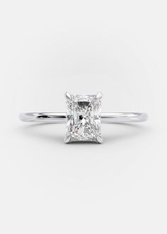 a princess cut diamond engagement ring on a white background with the center stone in the middle