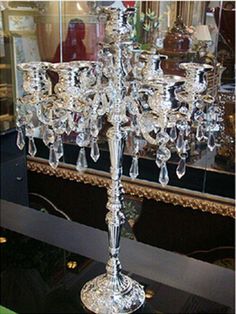 a silver candelabra with crystal candlesticks in front of a mirror