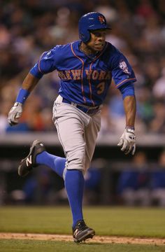 a baseball player running on the field during a game with fans in the stands behind him