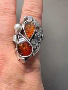 Baltic Amber with Pearl Gemstone Ring in sterling silver size 10 Materials: Silver 925, Baltic Amber, Pearl. Size 10  Face of the ring: Height-40mm, Width-12mm, Band- 40x12mm Unique Handcrafted One-of a-kind Design Ring Each Piece of Jewelry in my Collection is Absolutely One of a Kind! When you start wearing a piece of my jewelry you will fall in love with it more and more each day and feel that good Energy and Love that I pass into it while creating this piece of Art. A piece of Art created fo Luxury Amber Sterling Silver Rings, Unique Amber Sterling Silver Rings, Amber Sterling Silver Ring With Polished Finish, Sterling Silver Multi-stone Teardrop Ring, Amber Sterling Silver Rings For Anniversary, Amber Sterling Silver Ring, Artisan Amber Ring Jewelry, Unique Multi-stone Sterling Silver Rings, Unique Hallmarked Sterling Silver Opal Ring