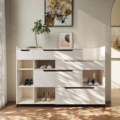 a white shelf with shoes on it in a room