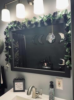 a bathroom sink with a mirror above it and lights on the wall next to it