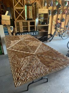 a table made out of wicker sitting in a room next to shelves and bicycles