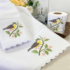 towels with birds and flowers on them are sitting on a bathroom counter next to a toilet