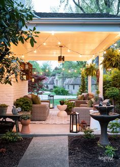 a covered patio with chairs, tables and lights