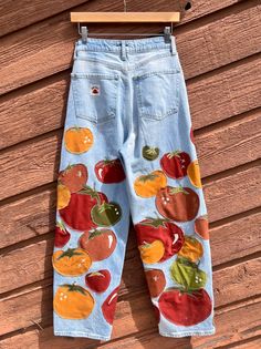 a pair of blue jeans with tomatoes and peppers on them