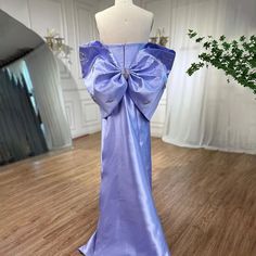 a mannequin wearing a purple dress with a large bow on it's back