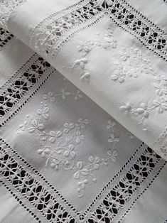 two pieces of white lace on top of each other with black and white trimmings