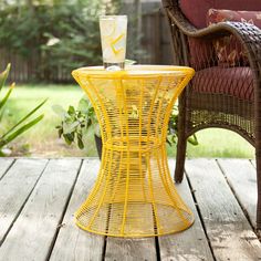 a yellow table sitting on top of a wooden deck